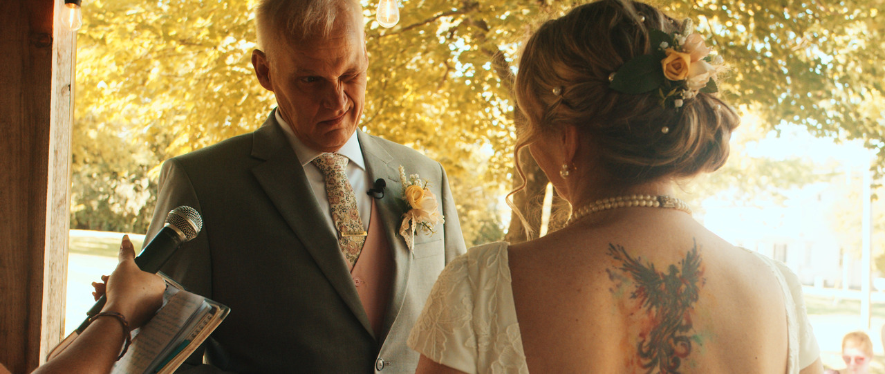 Groom smiles at bride as they look at each other.