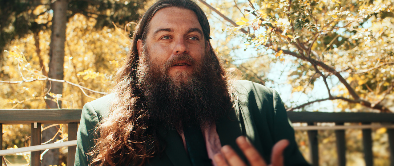 Guest sitting, being interviewed on porch.