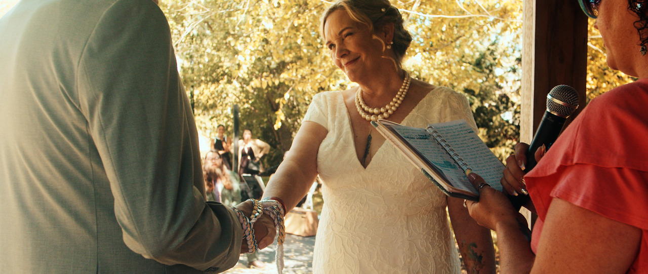 Bride and groom hands bound with ceremonial cords.