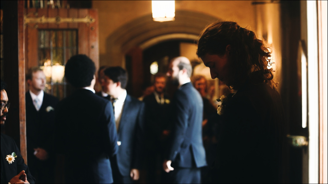 Groom standing patiently while guests arrive.