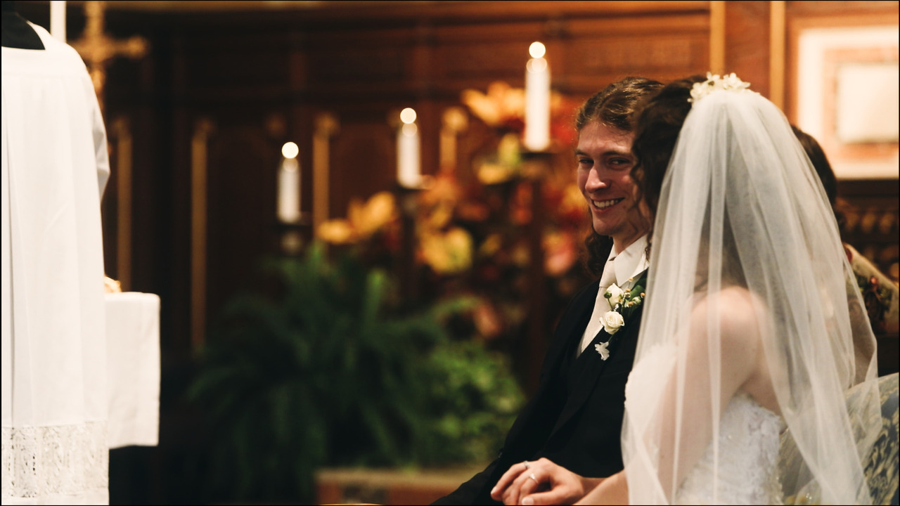 Bride and groom seated, laughing.