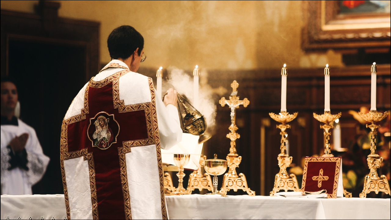 Priest processing incense around altar.