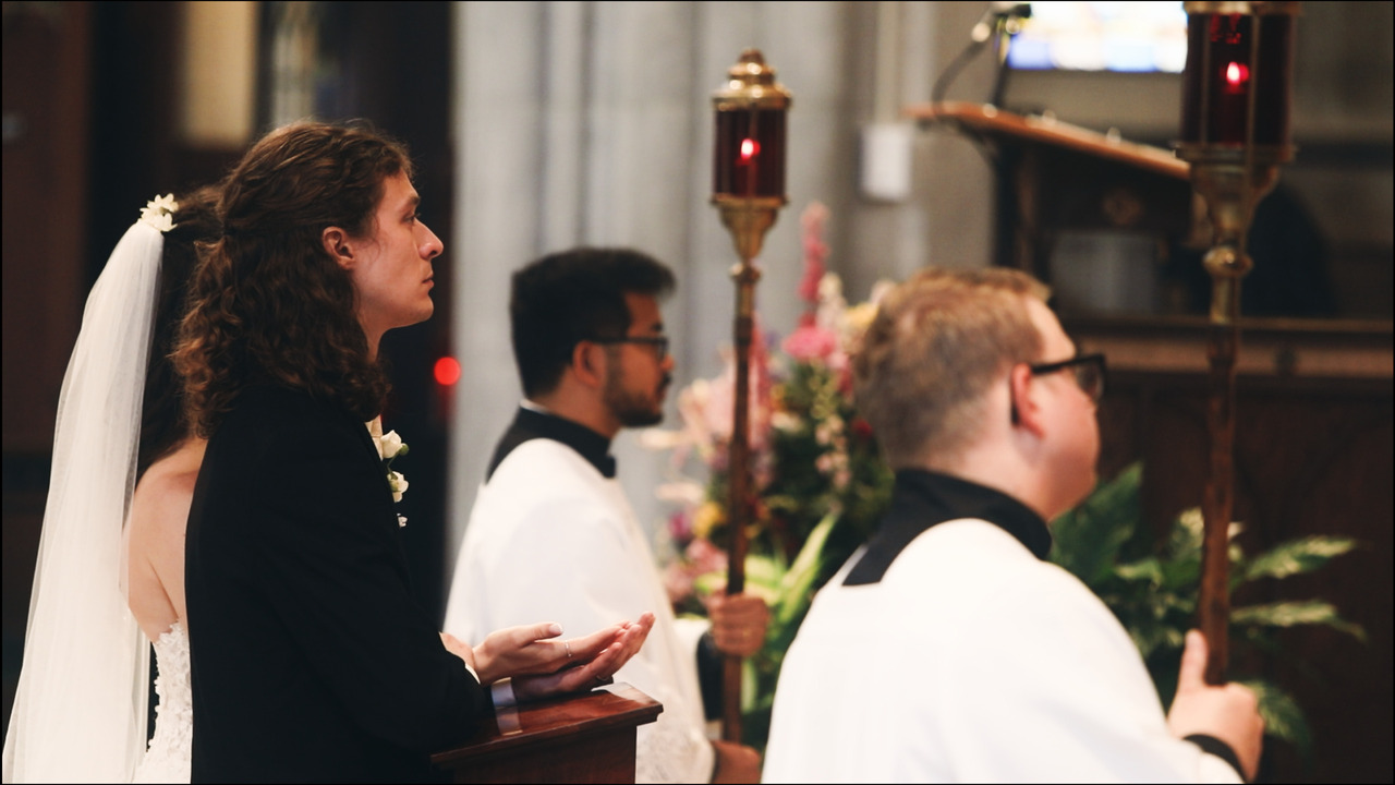 Bride and groom kneeling in front of altar, preparing to recieve communion.