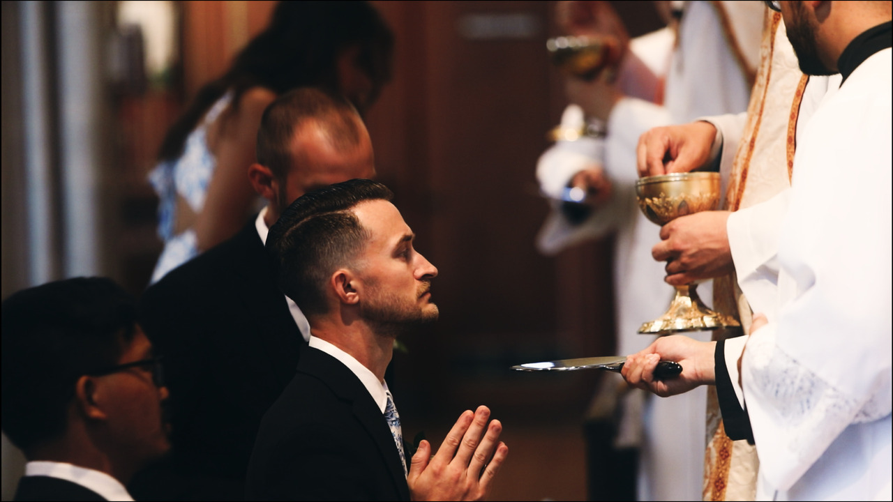 Groomsman kneeling for communion.