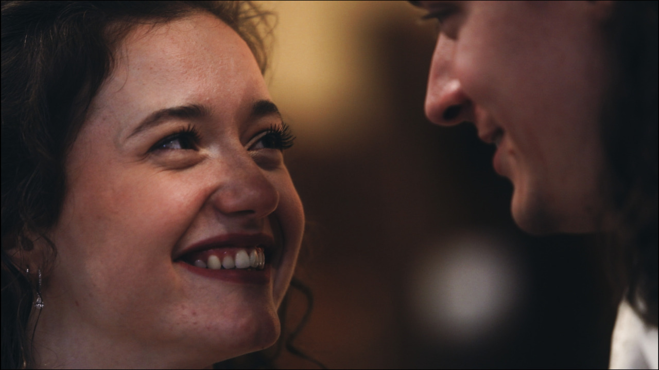Closeup of bride smiling at groom.