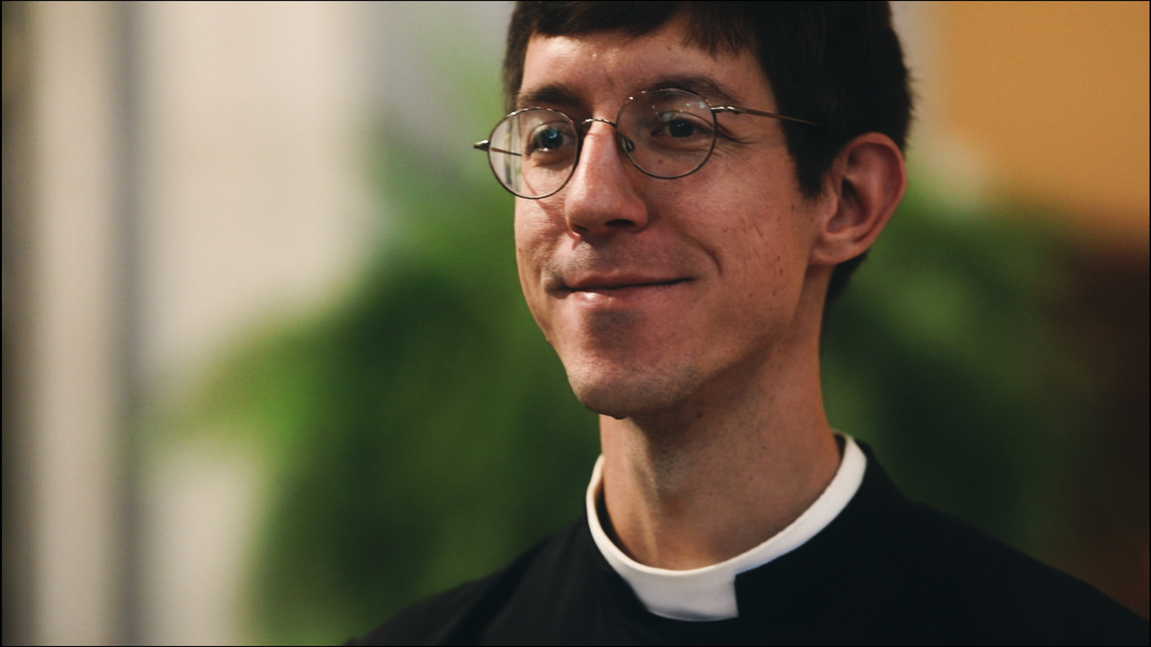 Closeup of priest smiling.