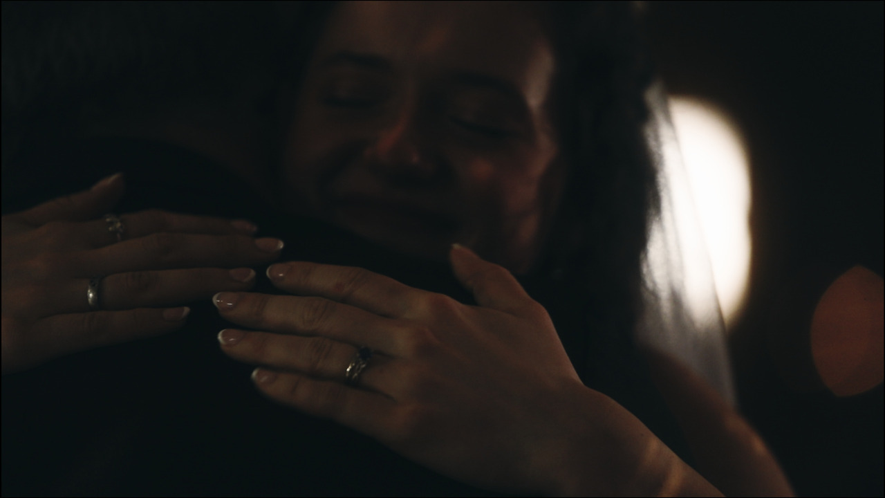 Closeup of bride hugging groom.