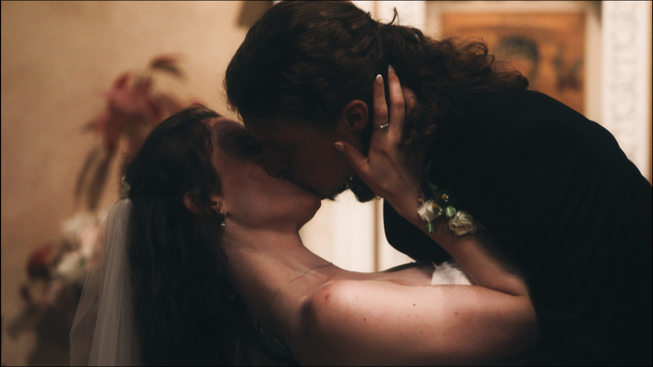 Groom dips bride and kisses her.