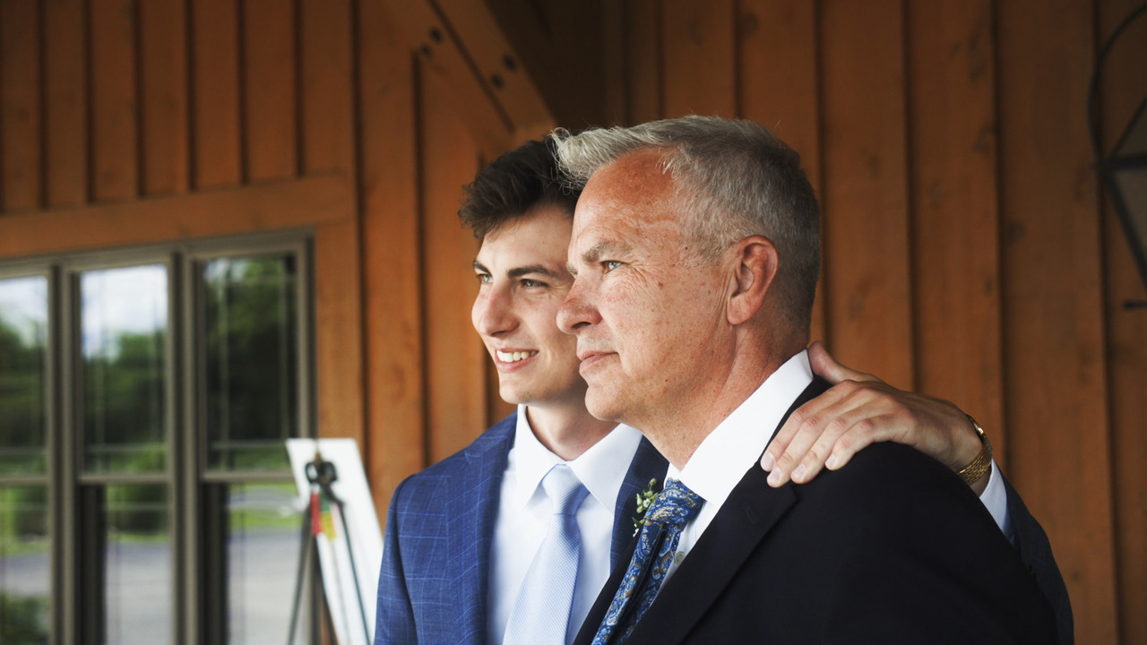 Groom gets photo taken with man.