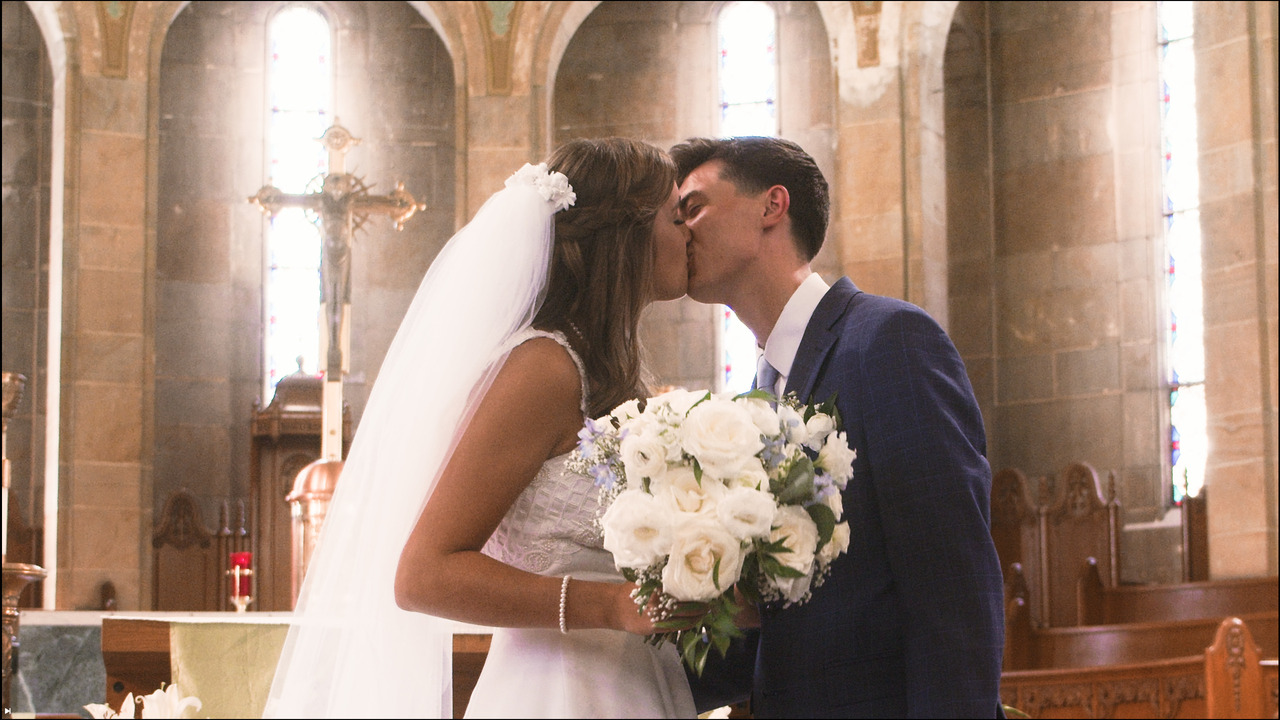 Bride and groom kiss in front of altar.