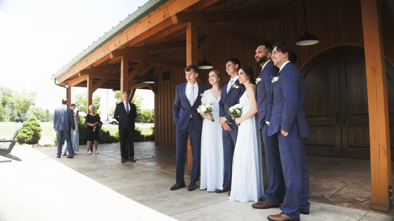 Groom gets photo taken with his siblings and friends in bridal party.