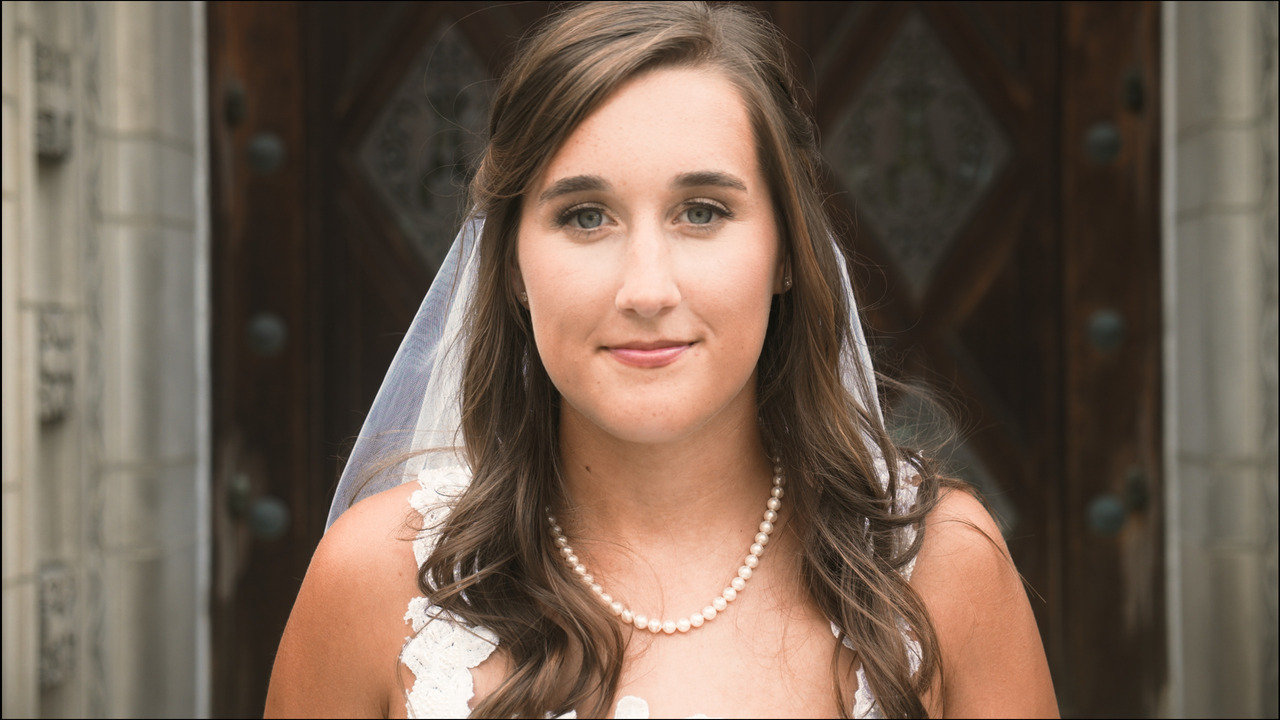 Bride looks into camera.