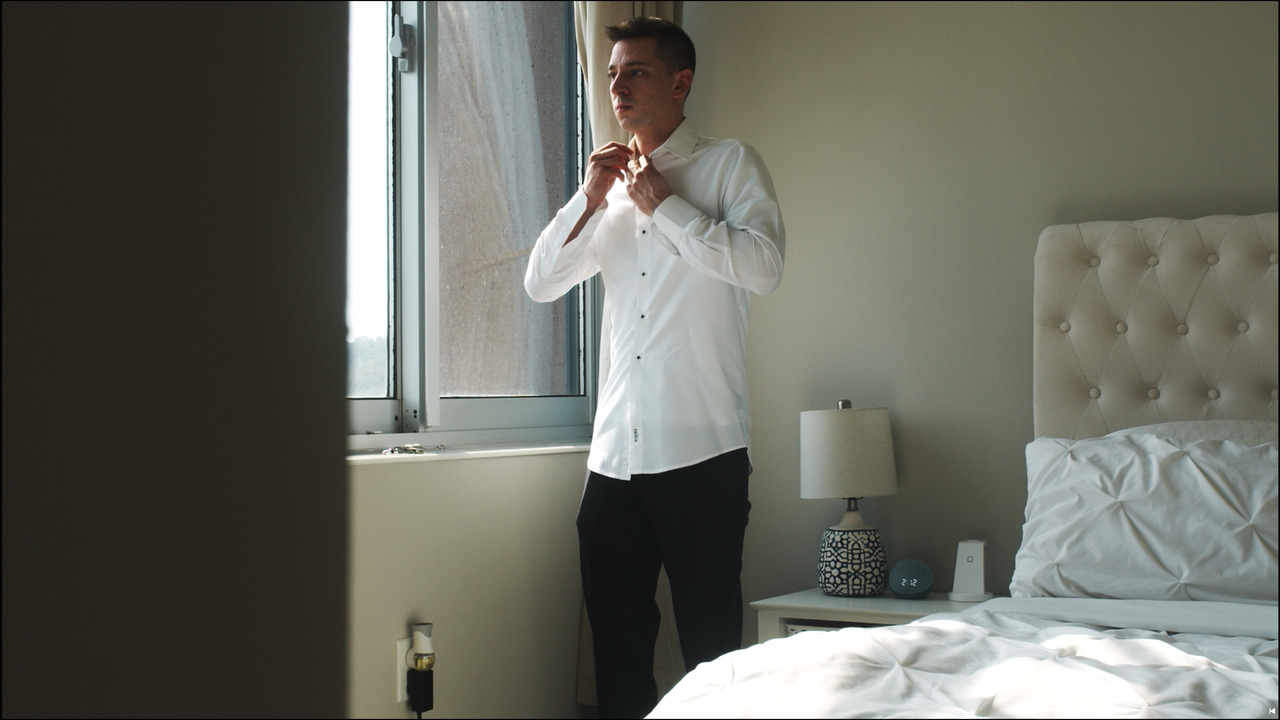 Groom adjusting his shirt collar.