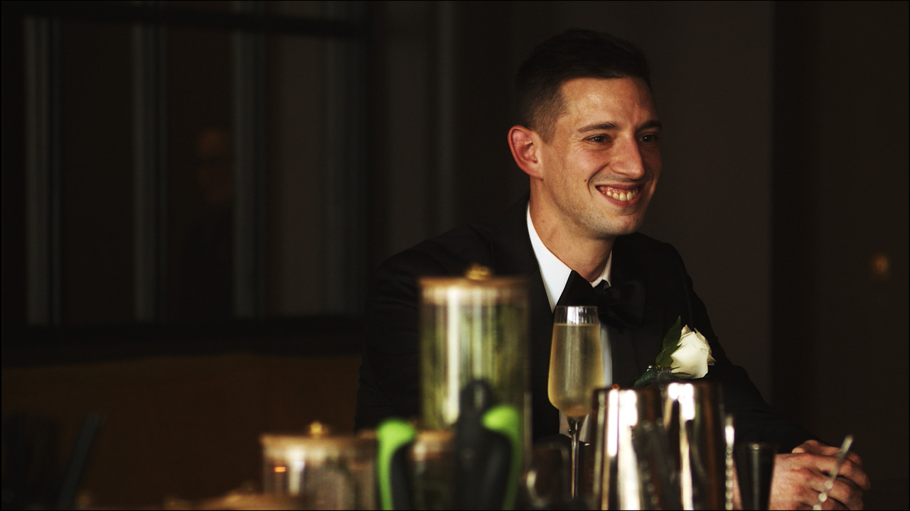 Groom sitting at bar.