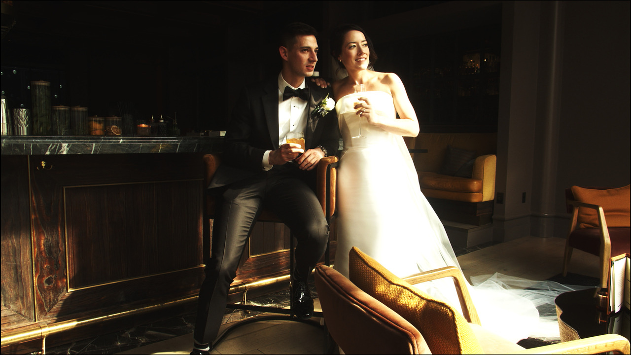 Bride and groom sitting together, staring out window.