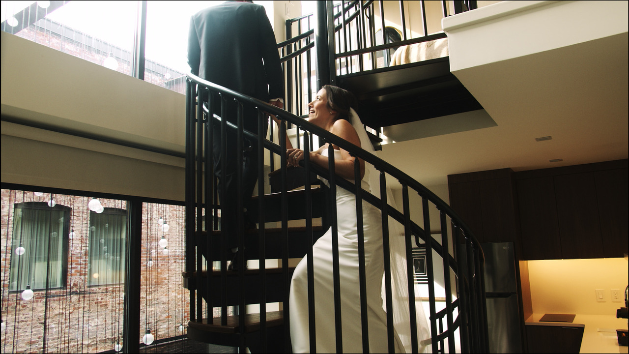 Bride and groom climbing spiral staircase.