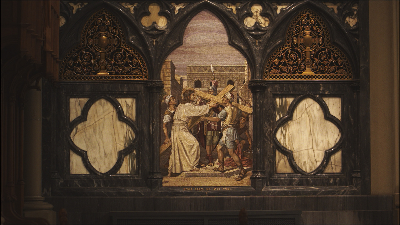 Mosaic of Christ picking being handed cross.