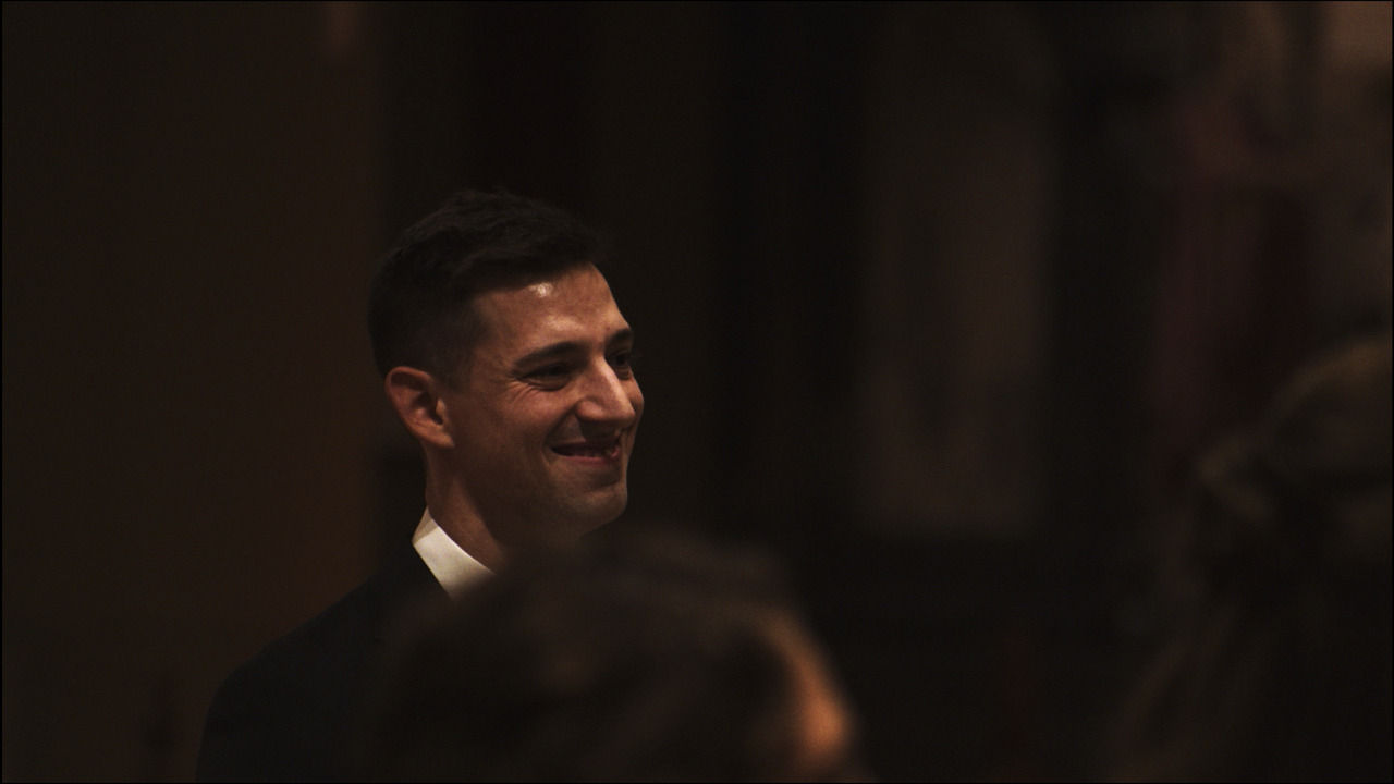 Groom smiling in front of altar.