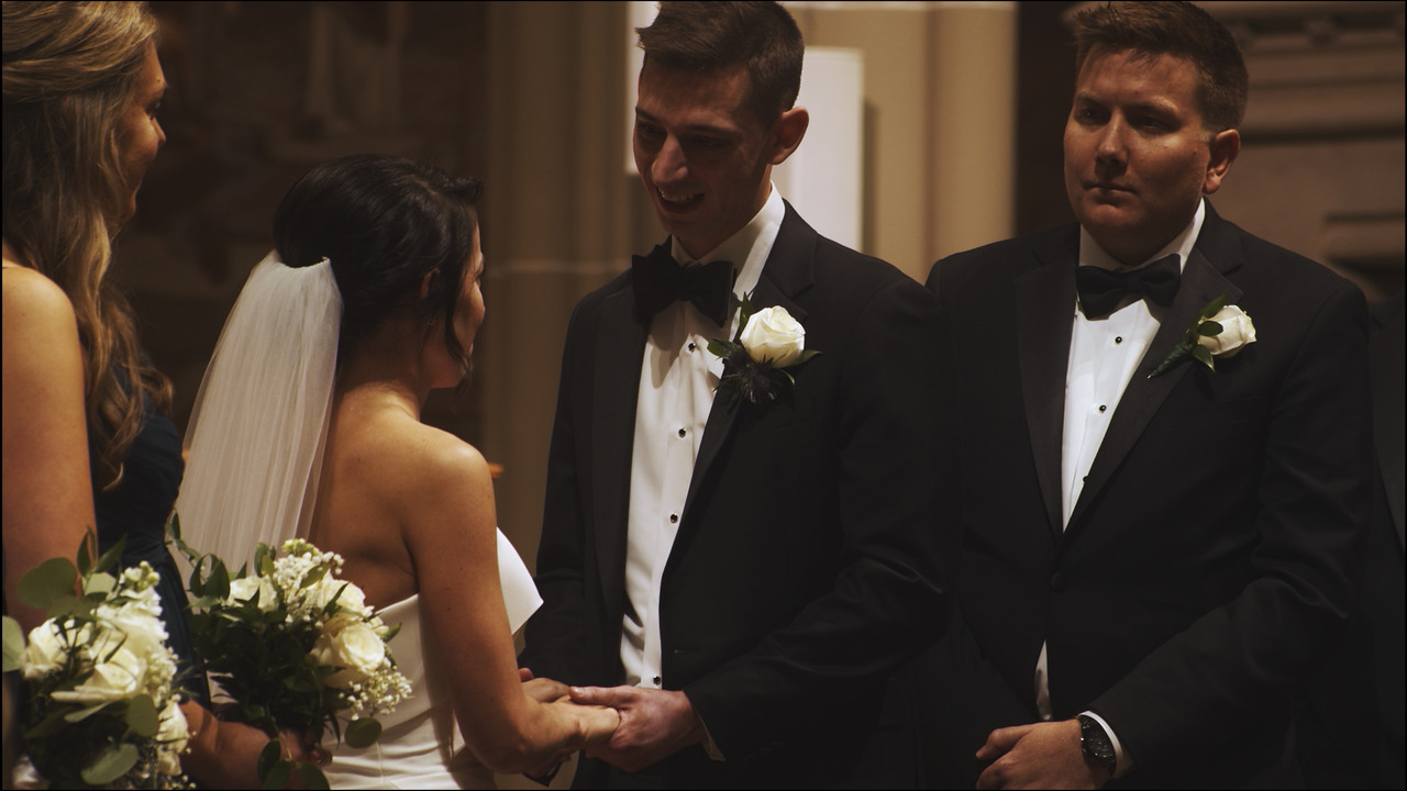 Groom saying vows to bride as he holds her hands.