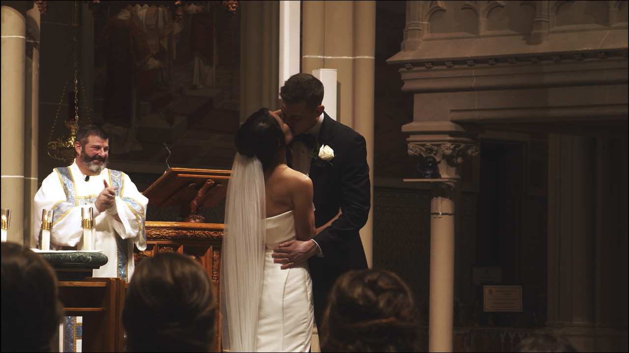 Bride and groom kiss in front of altar.