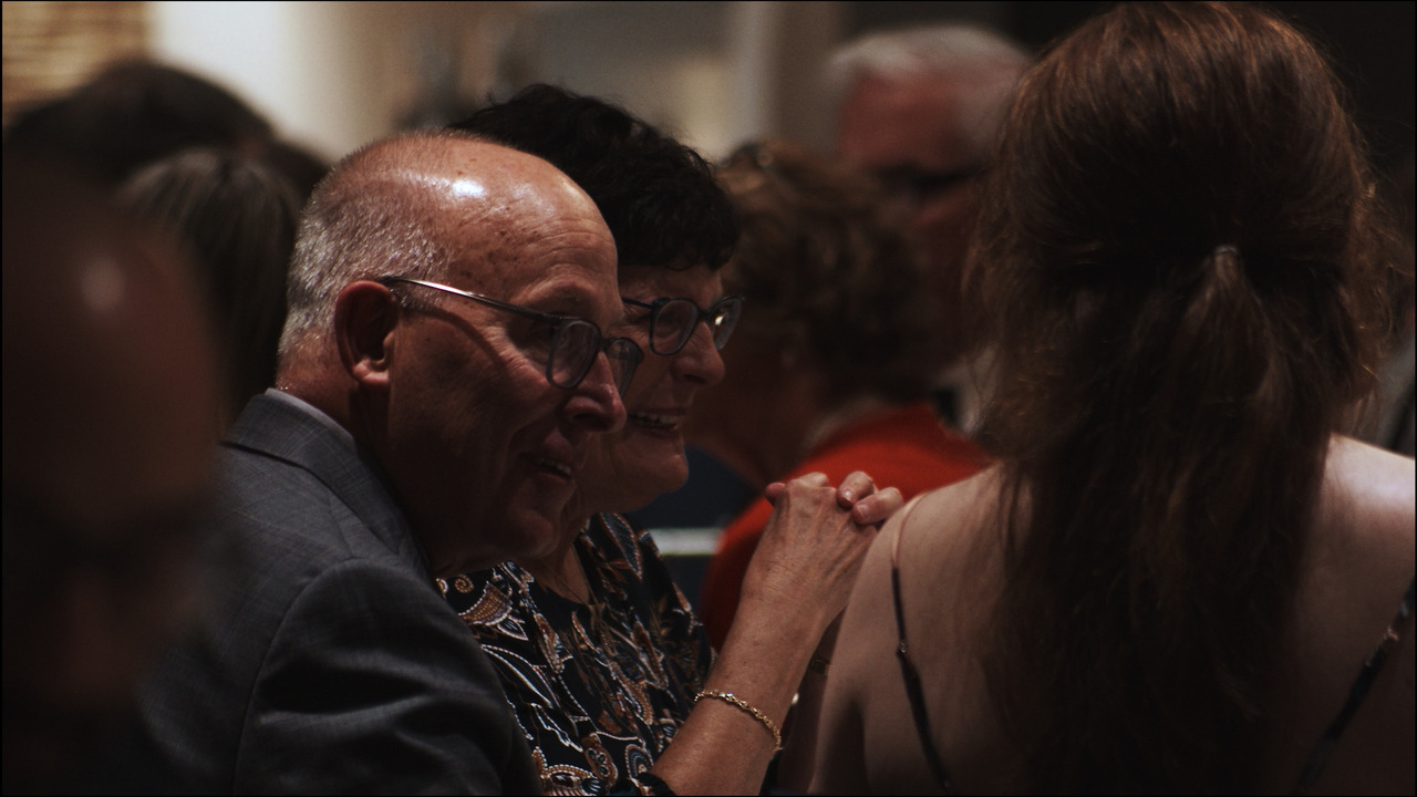 Elderly guests in conversation at reception.