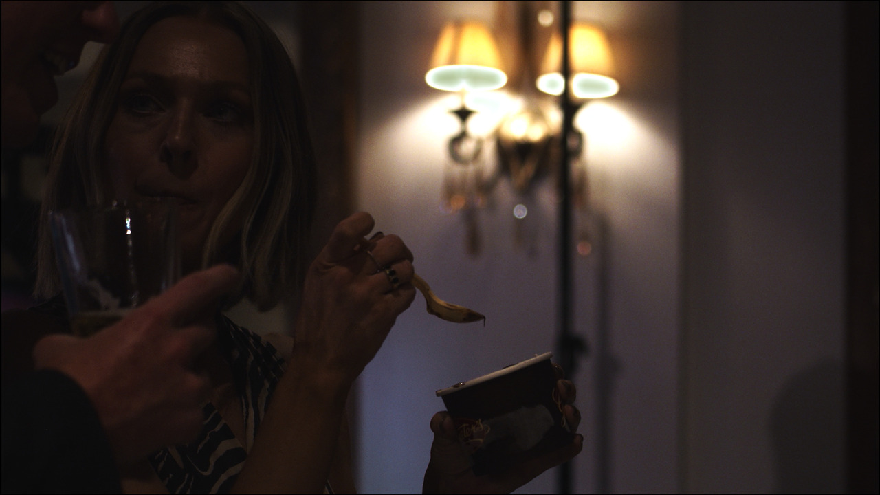 Woman eating cup of Greater's ice cream.