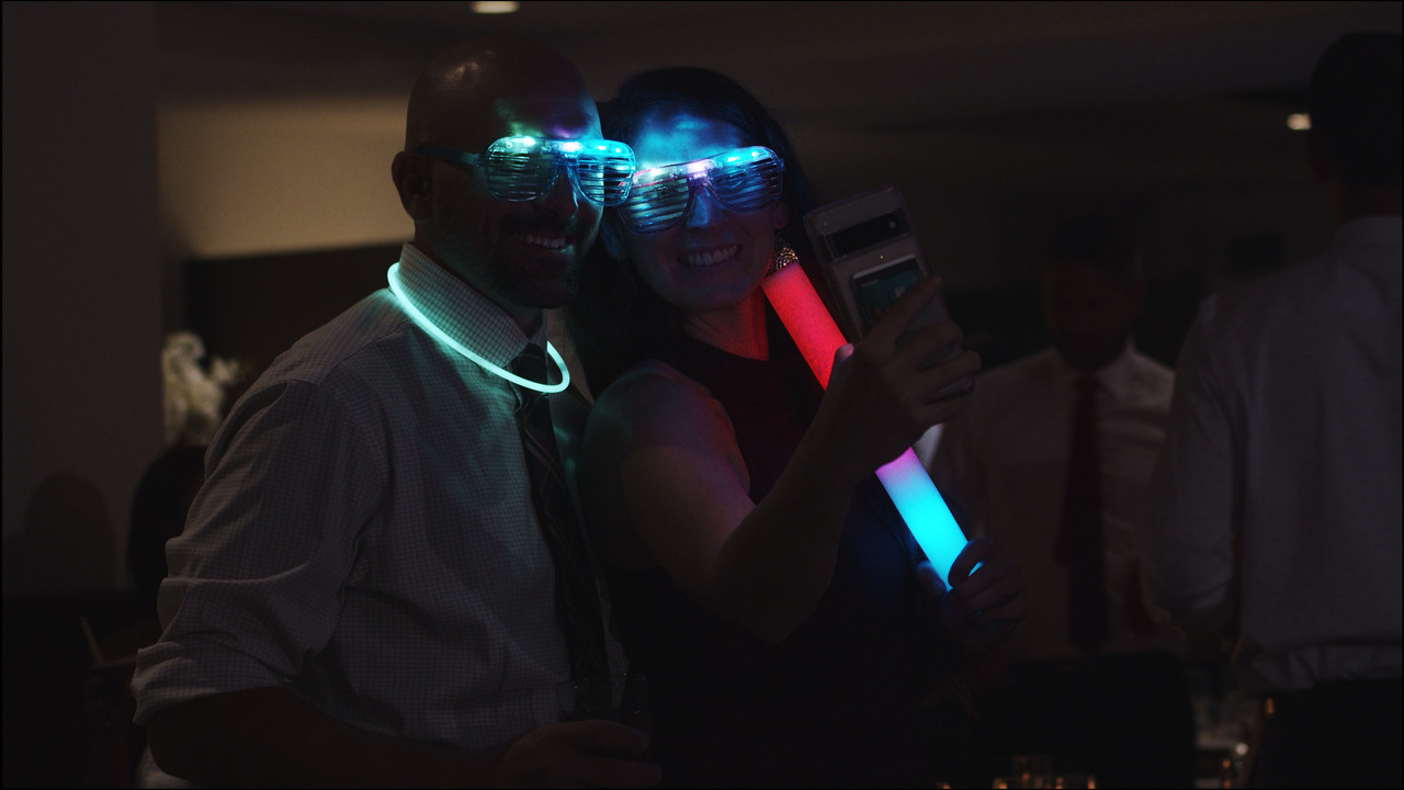 Guests with light-up glasses take selfie.