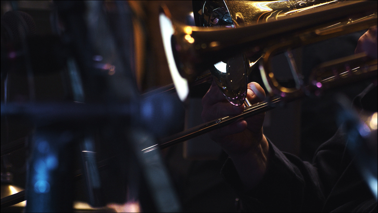Closeup of trombone as live band performs.