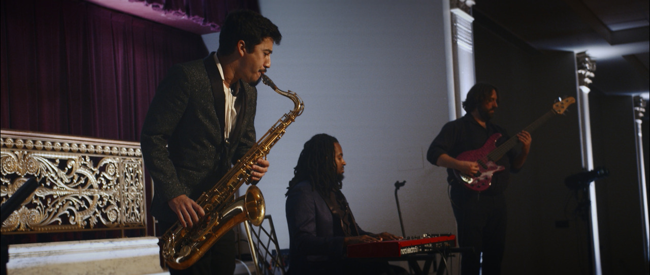 Live band performing (guitar, keyboard, saxaphone).