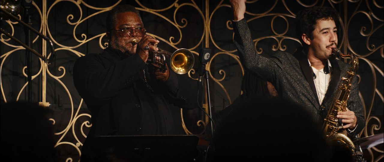 Trumpet and saxhophone players performing.