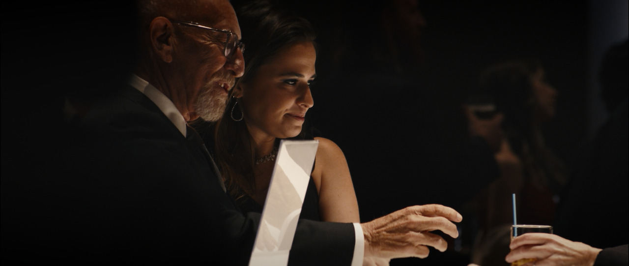 Older man and middle-aged woman get drink from bar.