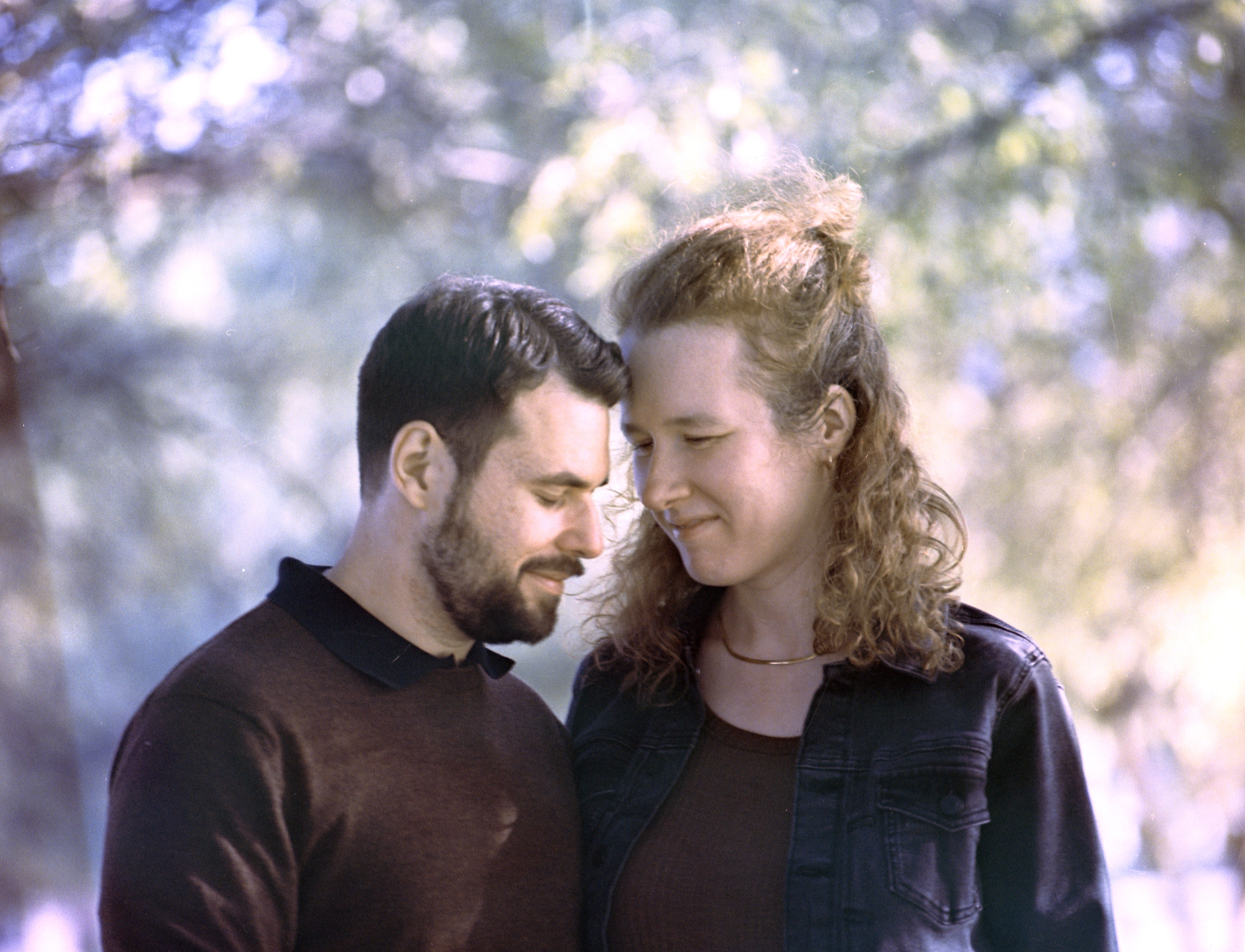 Couple smiling and looking down, color.