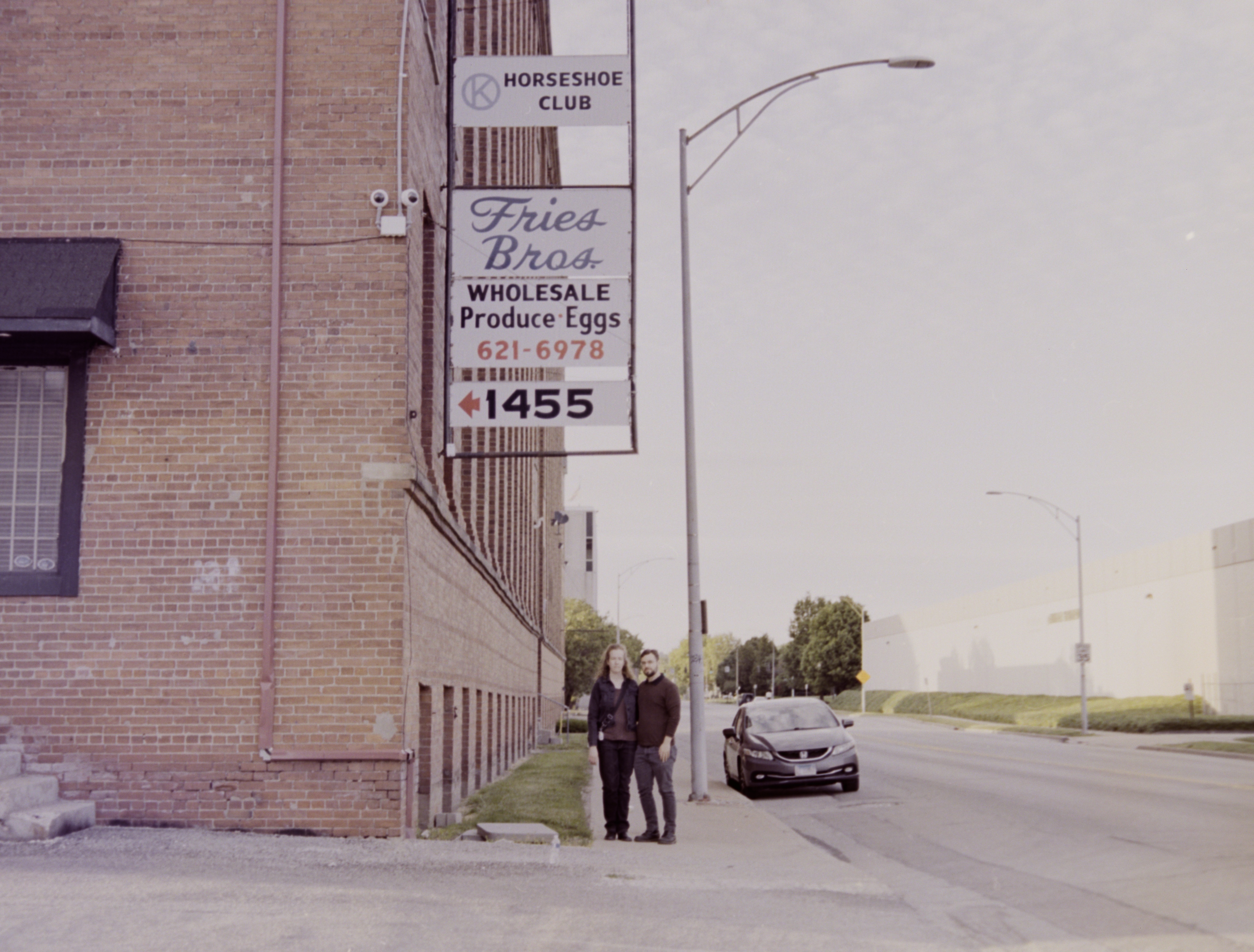 Couple standing under warehouse signs, color.