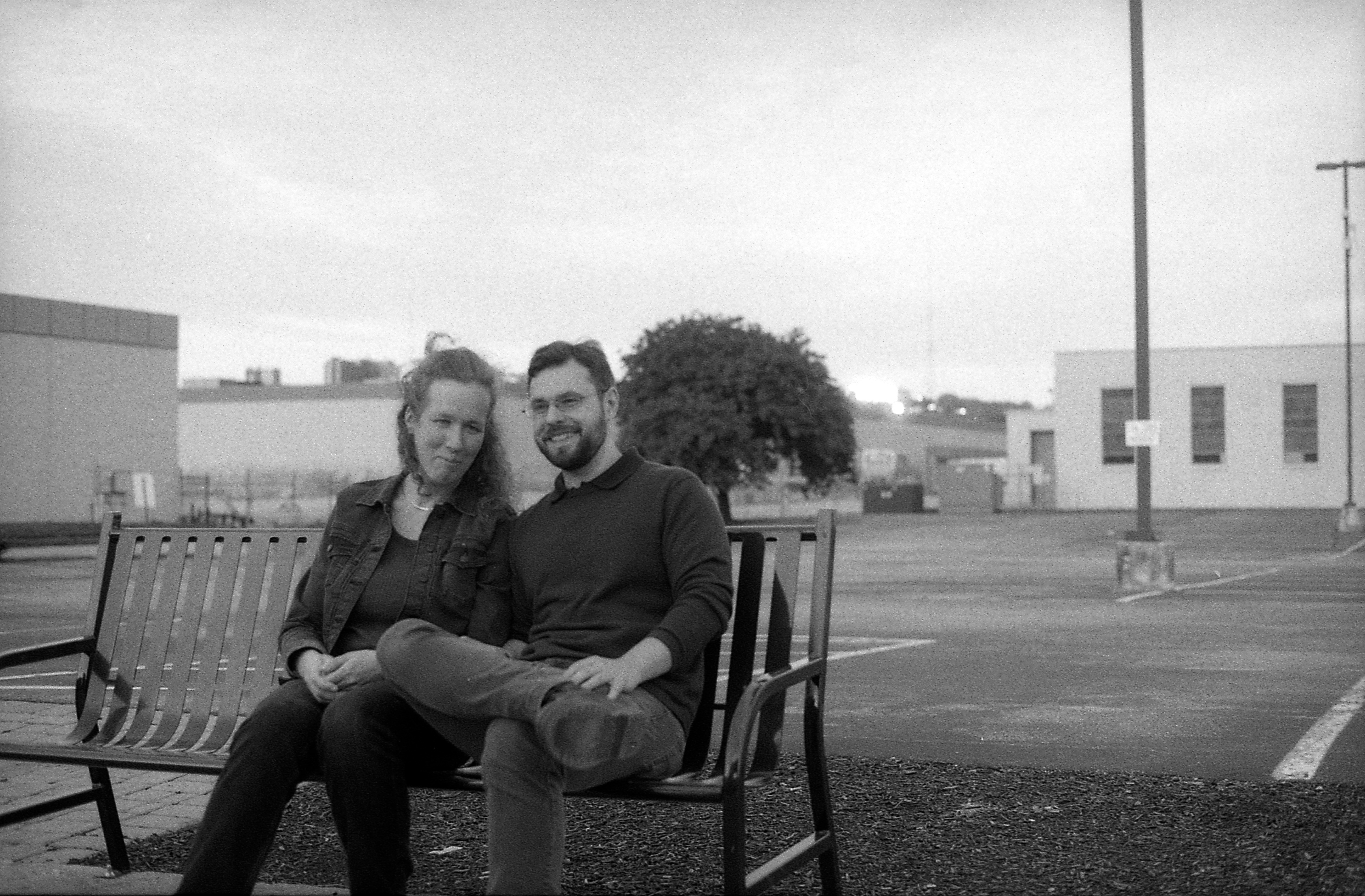 Couple sitting on bench, black and white.
